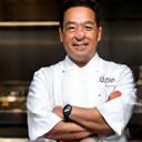 シェフコートを着てZenith Grillworksグリルの前で腕を組む佐藤健一シェフ。